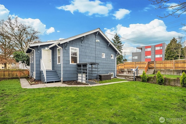 back of house with central AC, a yard, and fence