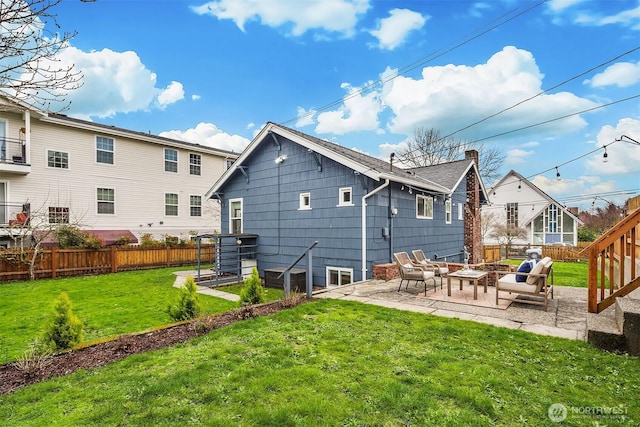 back of property with a yard, a patio, a chimney, and fence