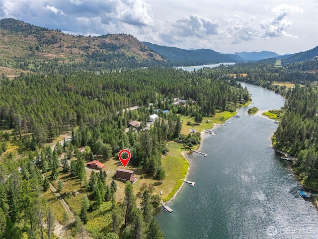 aerial view featuring a wooded view and a water and mountain view