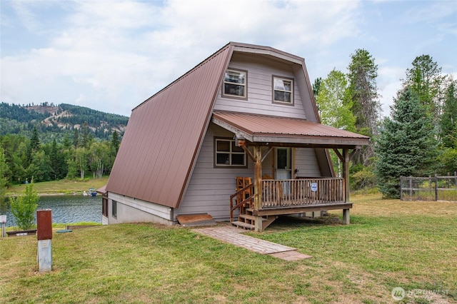 view of front of home featuring a water view, metal roof, a front lawn, and a gambrel roof