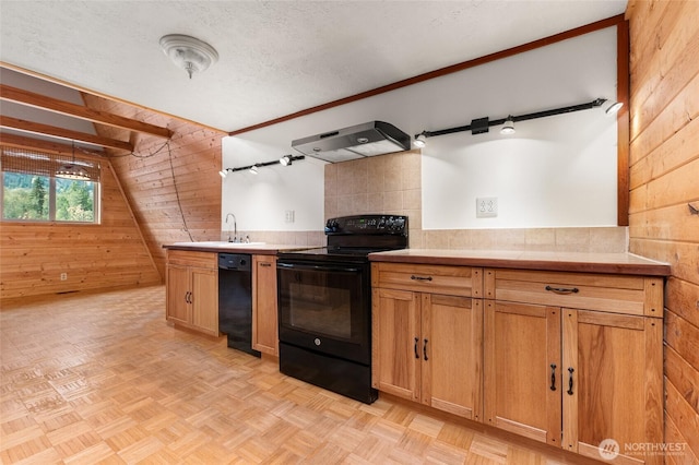 kitchen featuring light countertops, a textured ceiling, wooden walls, black appliances, and exhaust hood