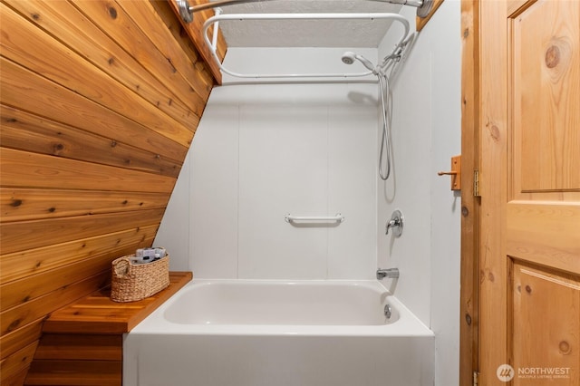 bathroom with shower / bathing tub combination and wooden walls