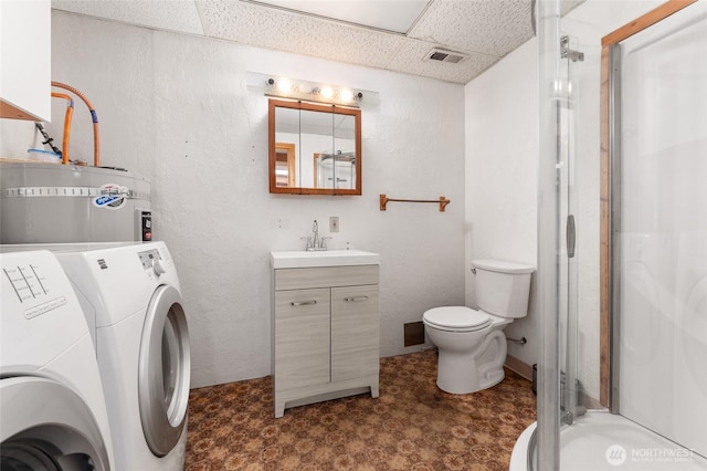 clothes washing area with laundry area, visible vents, strapped water heater, washer and dryer, and a sink