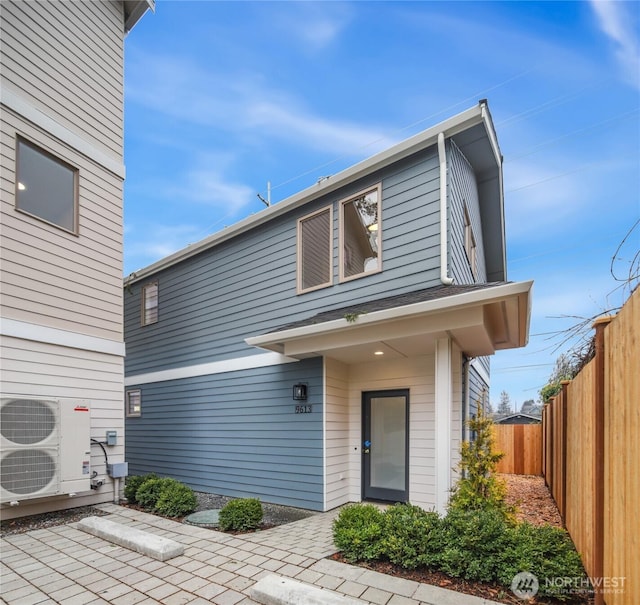 view of front of property featuring ac unit and fence