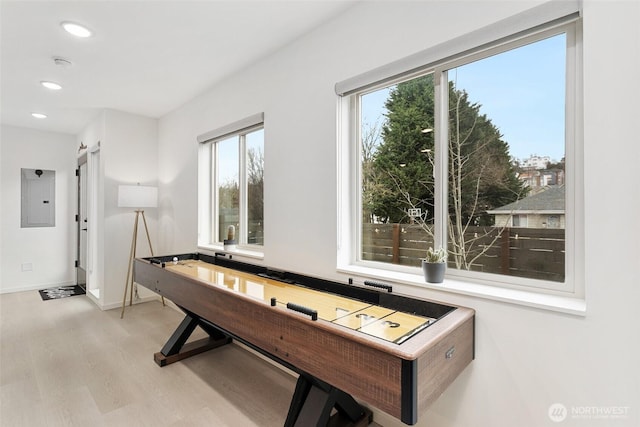 rec room with light wood-type flooring, electric panel, baseboards, and recessed lighting