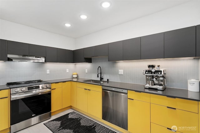 kitchen with tasteful backsplash, dark countertops, stainless steel appliances, under cabinet range hood, and a sink