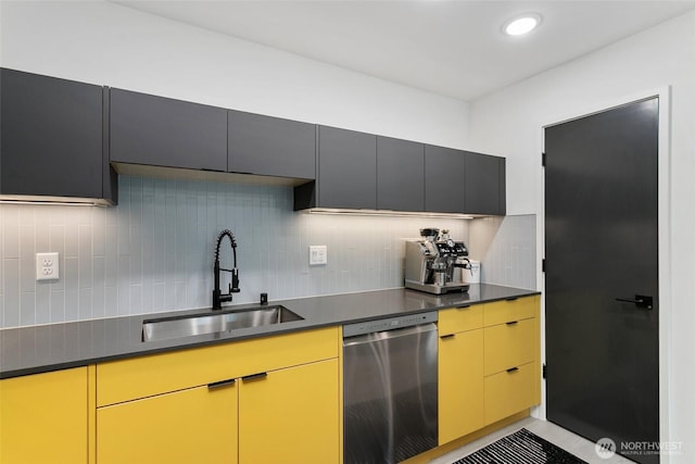 kitchen featuring dark countertops, recessed lighting, decorative backsplash, a sink, and dishwasher