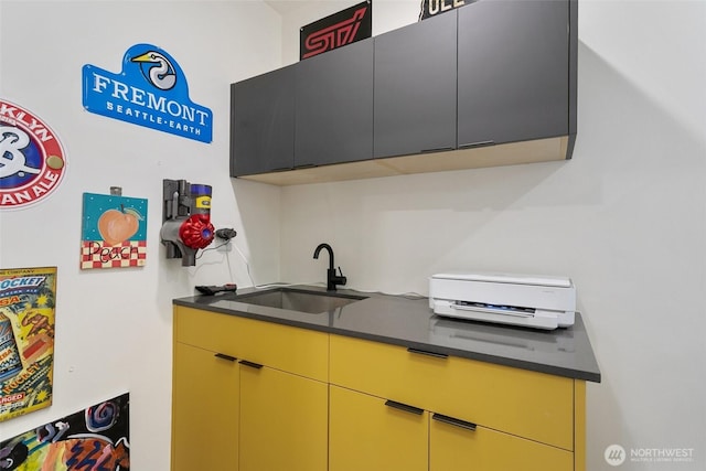 kitchen featuring dark countertops and a sink