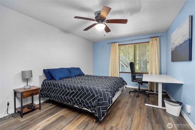 bedroom featuring a ceiling fan, baseboards, and wood finished floors