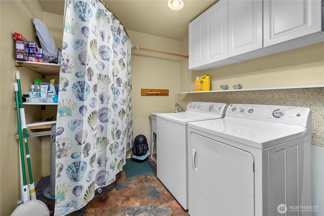 clothes washing area with cabinet space, stone finish flooring, and washing machine and clothes dryer