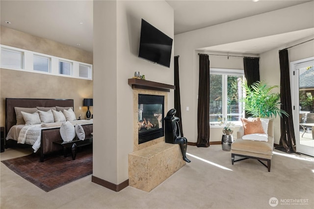 carpeted bedroom featuring access to exterior, a tile fireplace, and baseboards