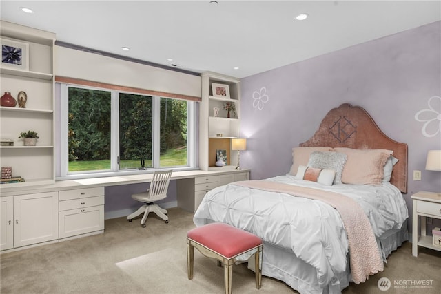 bedroom with recessed lighting, built in desk, and light colored carpet