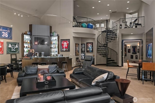 living area featuring stairs, recessed lighting, a towering ceiling, and wet bar