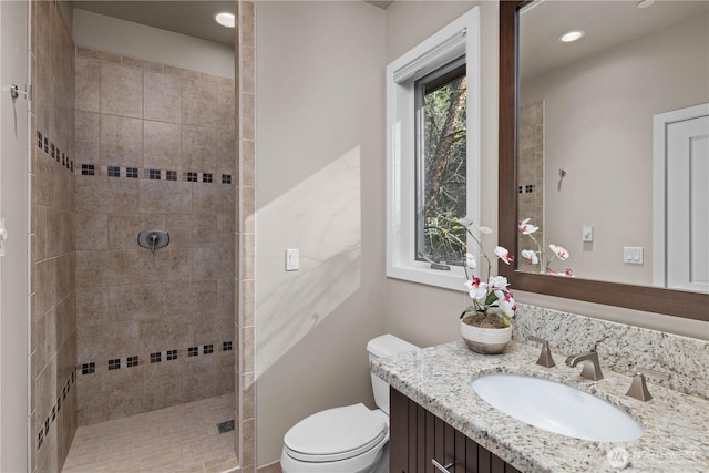 full bathroom with toilet, recessed lighting, a tile shower, and vanity