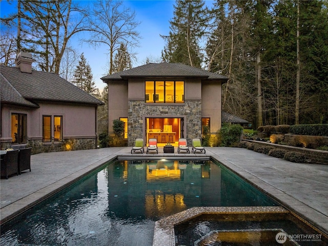 pool featuring a patio and exterior fireplace