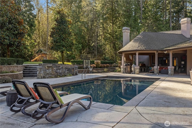 view of pool with a patio, a playground, and a fenced in pool