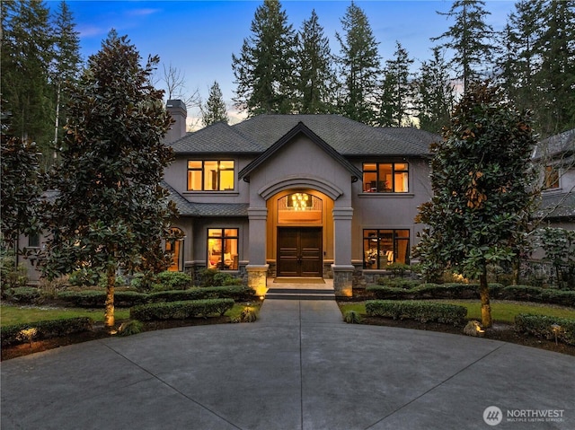 view of front of property featuring stone siding and stucco siding