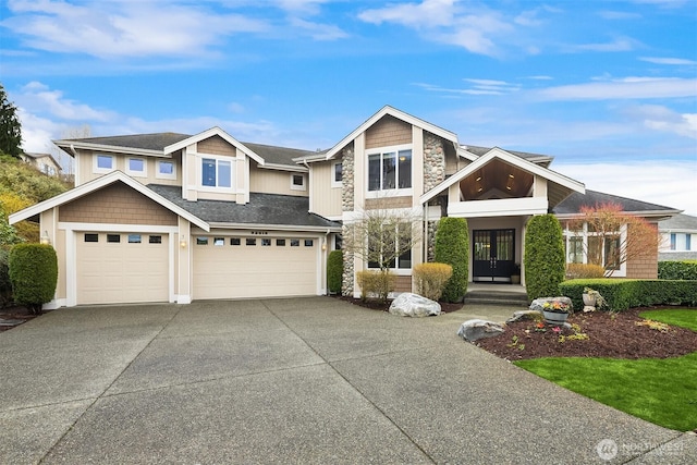 view of front of house featuring stone siding, french doors, concrete driveway, and a garage