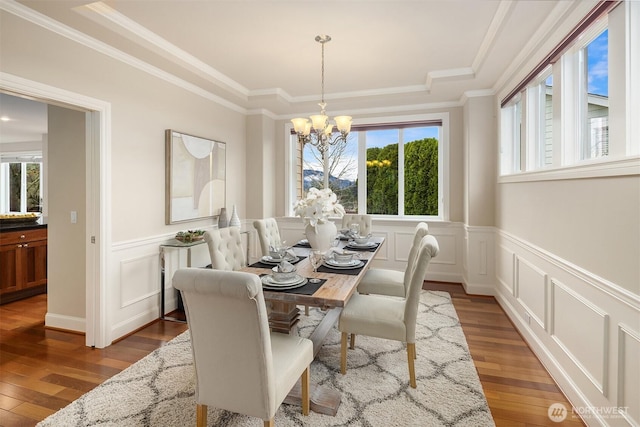 dining room featuring a chandelier, hardwood / wood-style floors, and ornamental molding