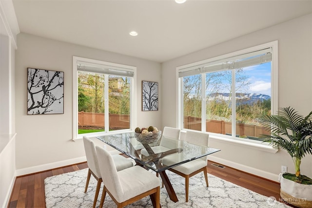 dining area featuring visible vents, a healthy amount of sunlight, baseboards, and wood finished floors