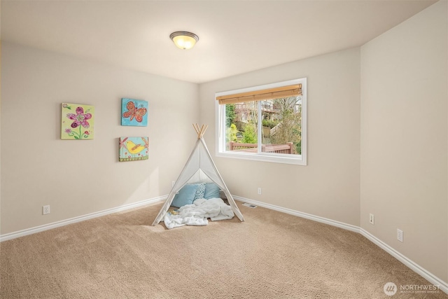 rec room with baseboards and carpet flooring