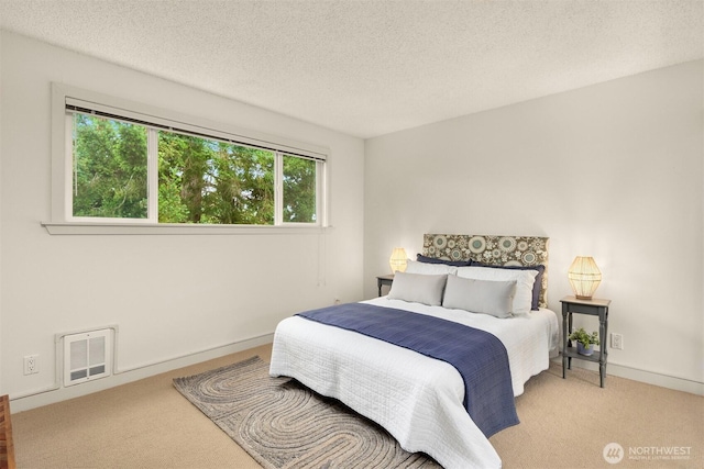 bedroom with light carpet, baseboards, visible vents, and a textured ceiling