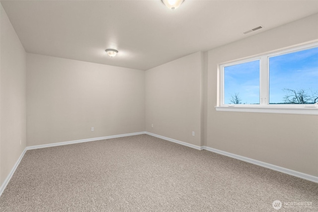 carpeted spare room featuring baseboards and visible vents