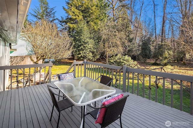 deck with a yard and outdoor dining space