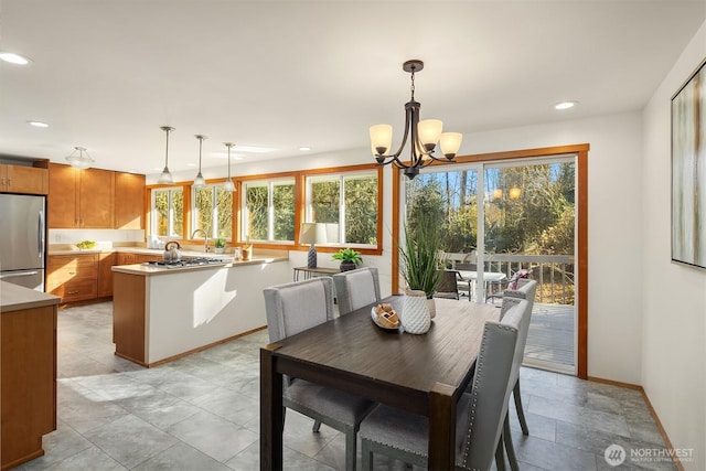 dining room with a chandelier, baseboards, and recessed lighting