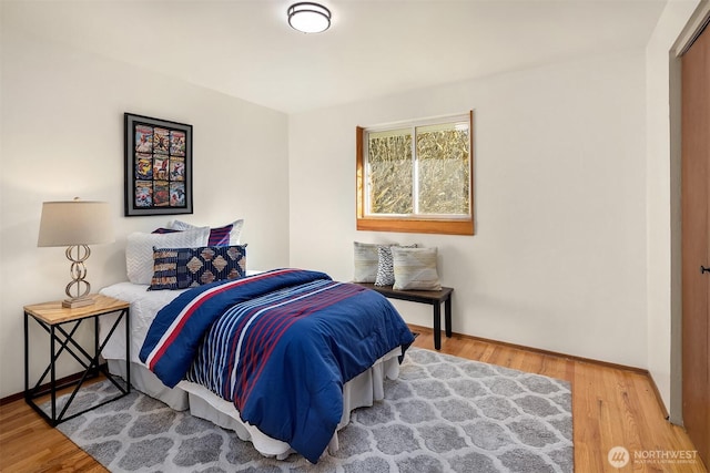 bedroom with baseboards and wood finished floors