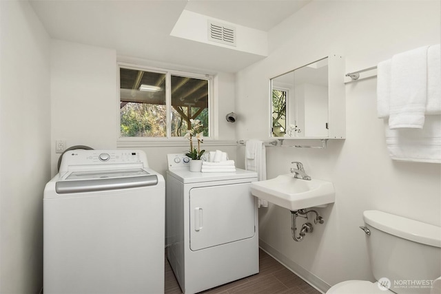 laundry area featuring laundry area, baseboards, visible vents, dark wood finished floors, and independent washer and dryer