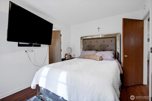 bedroom with wood finished floors and baseboards