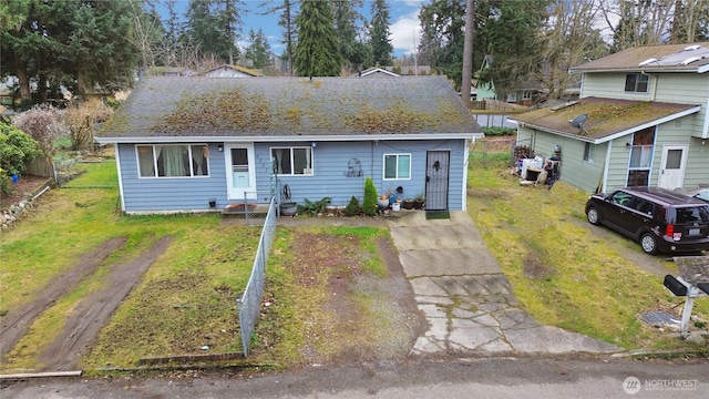 view of front of property with a shingled roof and a front lawn