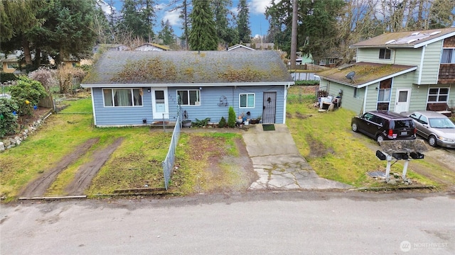 view of front of house with a shingled roof and a front yard