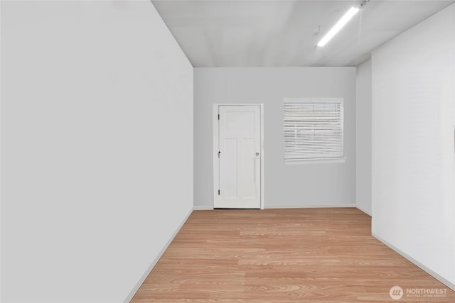 empty room with light wood-style flooring and baseboards