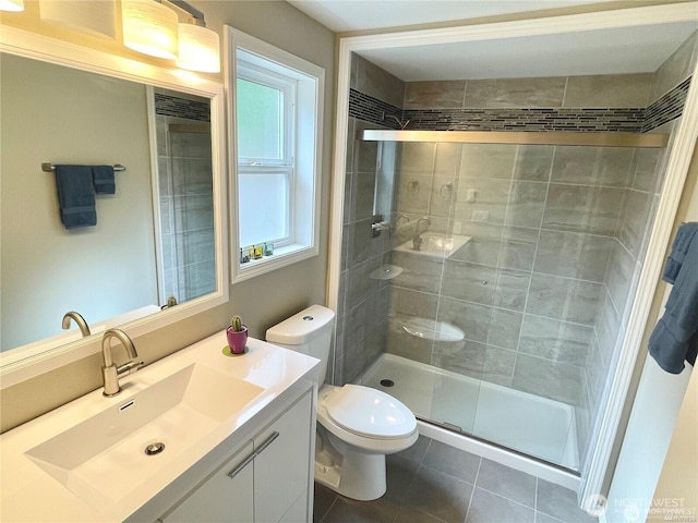 bathroom featuring tile patterned flooring, a shower stall, toilet, and vanity