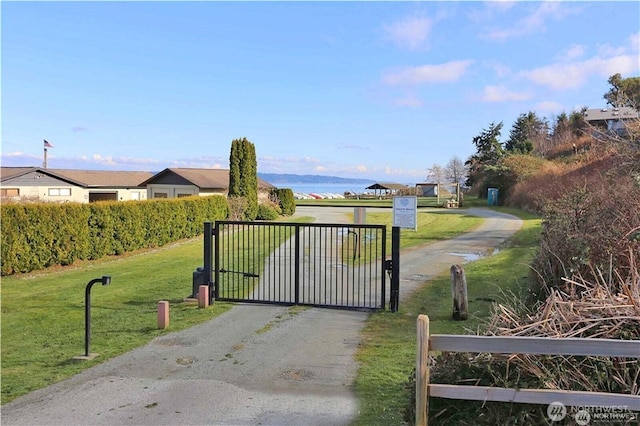 view of gate with a yard