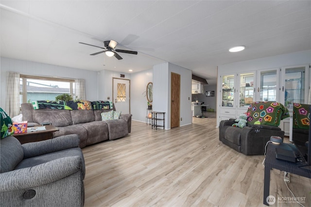 living room with a ceiling fan and light wood finished floors