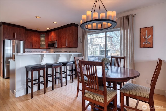 dining room featuring light wood finished floors, a chandelier, and recessed lighting