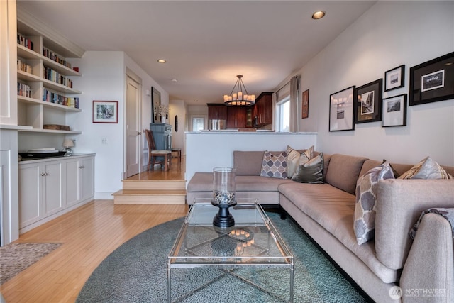 living area with a chandelier, light wood-style flooring, and recessed lighting