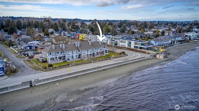 drone / aerial view with a water view, a residential view, and a beach view