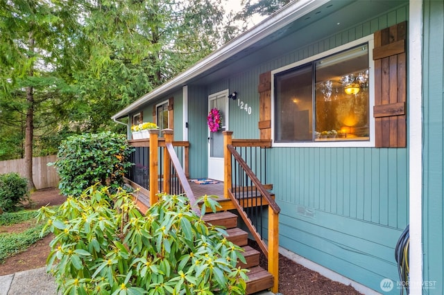 property entrance with fence and a deck