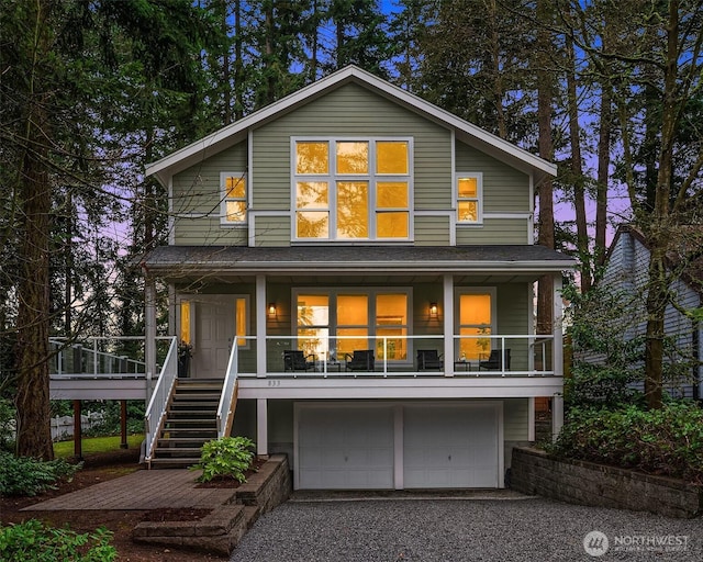 view of front facade with driveway, a porch, stairway, and an attached garage