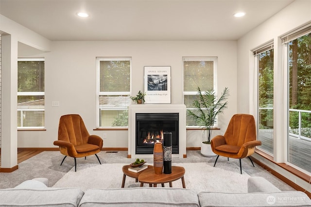 living area featuring plenty of natural light, recessed lighting, and a glass covered fireplace