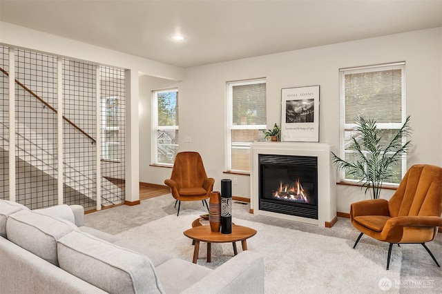 living area with recessed lighting, carpet, a glass covered fireplace, and baseboards