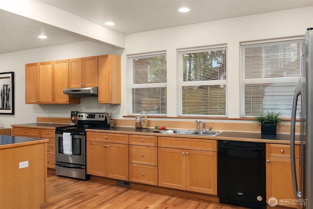 kitchen with recessed lighting, under cabinet range hood, stainless steel appliances, a sink, and light wood-style floors