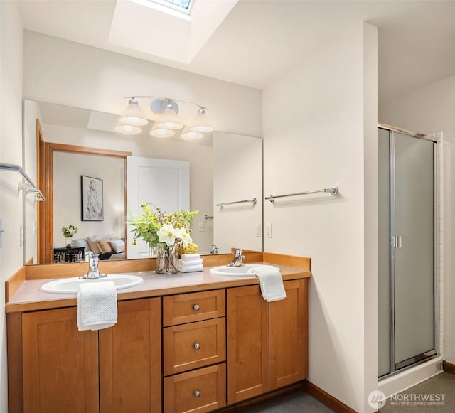 full bathroom featuring double vanity, a skylight, a sink, and a shower stall