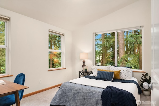 bedroom featuring vaulted ceiling, multiple windows, carpet flooring, and baseboards