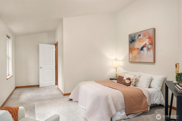 carpeted bedroom with vaulted ceiling and baseboards