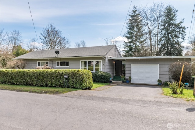 ranch-style house featuring aphalt driveway and an attached garage